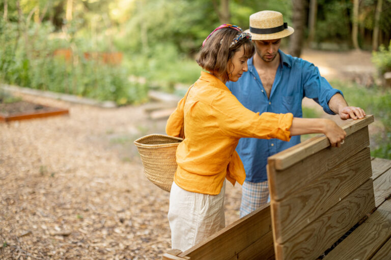 couple throwing cut grass to compost wooden bin 2023 11 27 05 19 08 utc